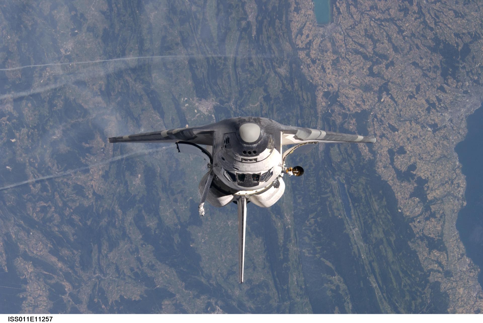 View of STS-114 backdropped by Earth's oceans and clouds as seen by the International Space Station crew