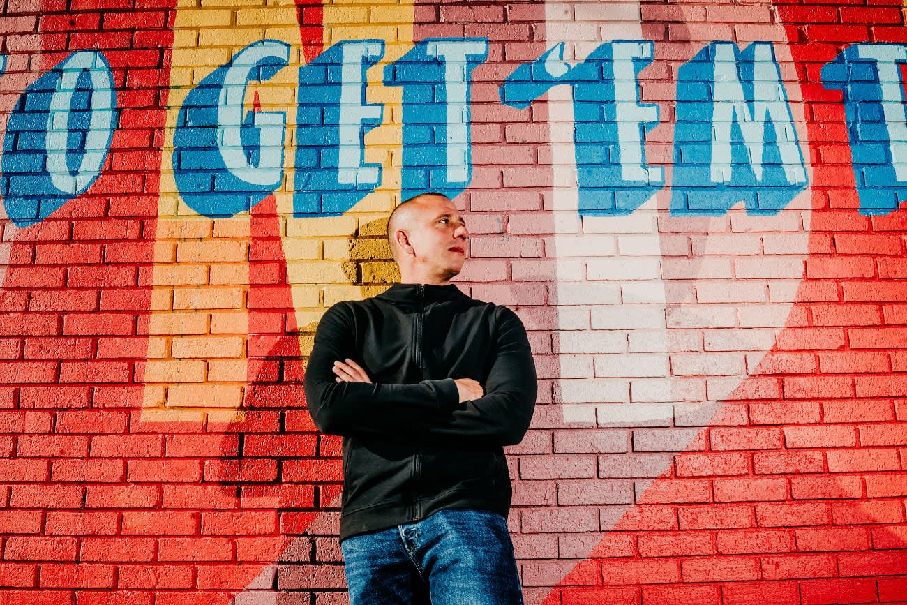 Photo of Nader Dabit posing in front of street art.