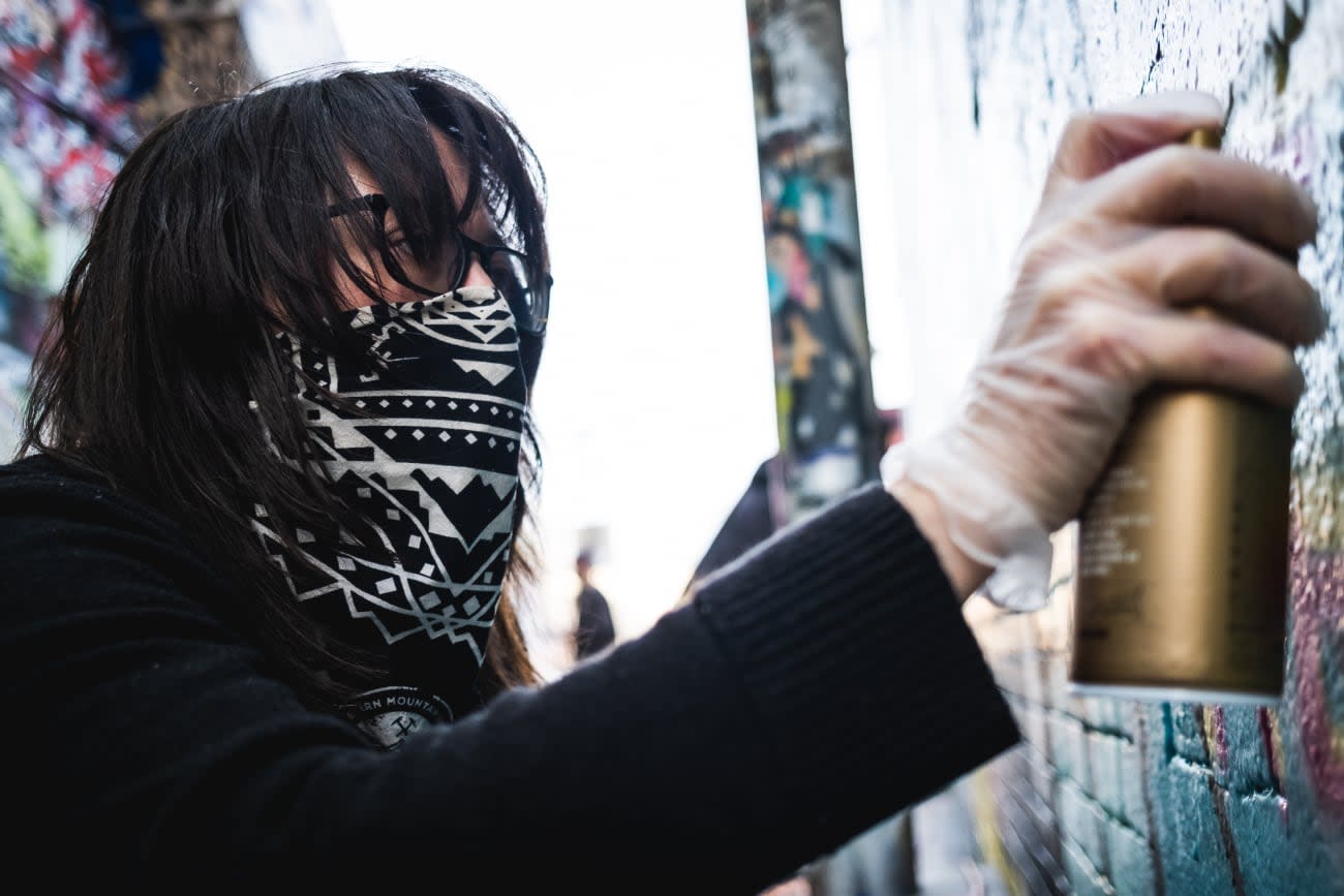 Photo of Jory Burson painting street art.