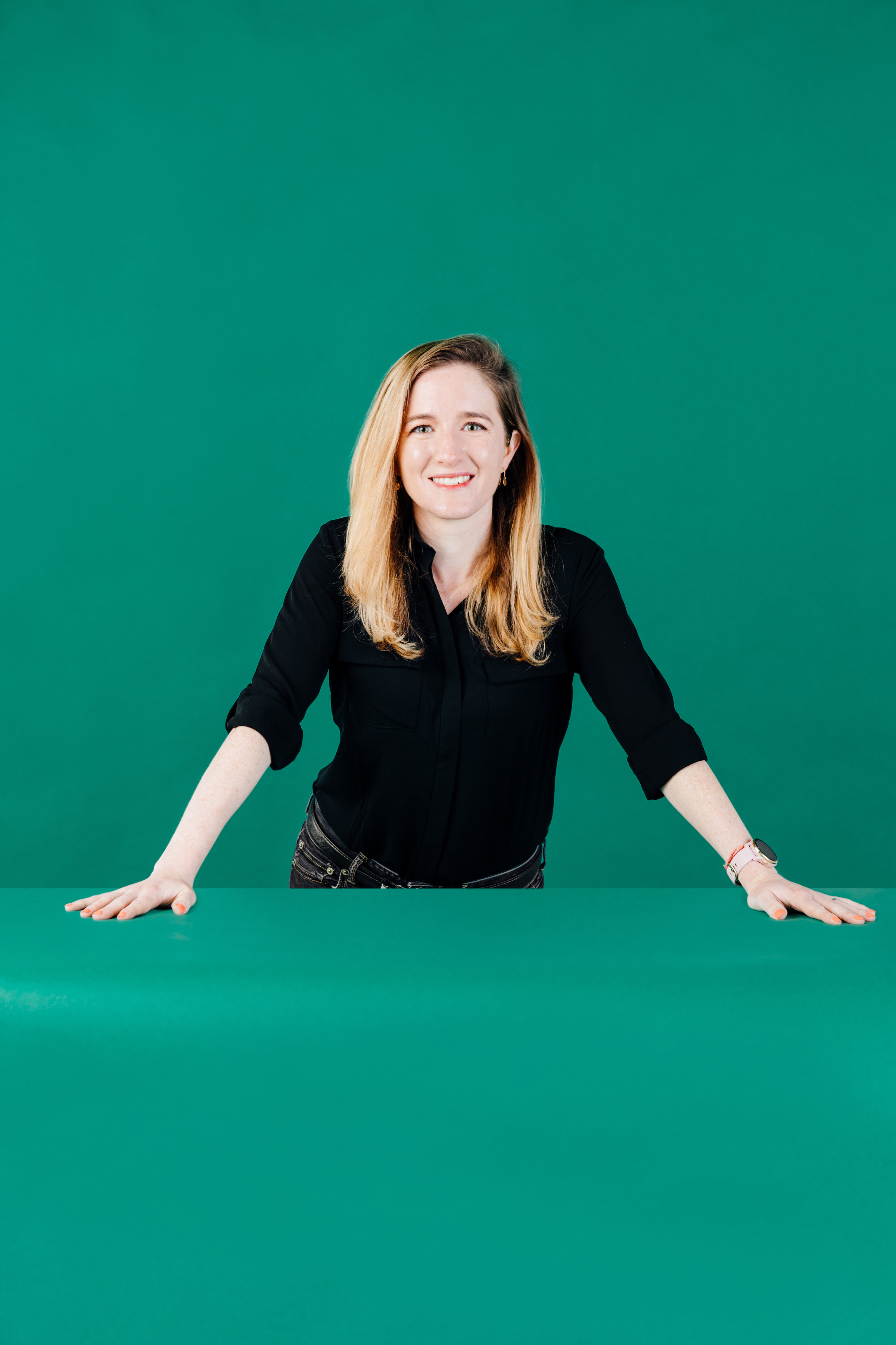 Author Keeley smiling at the camera against a kelly green backdrop