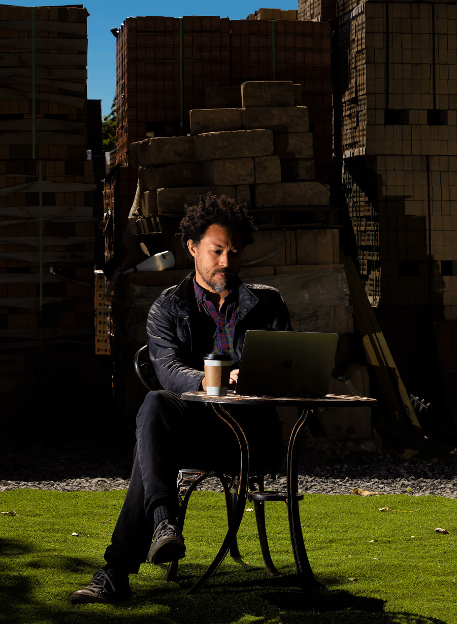 Photo of David working in front of an industrial backdrop.