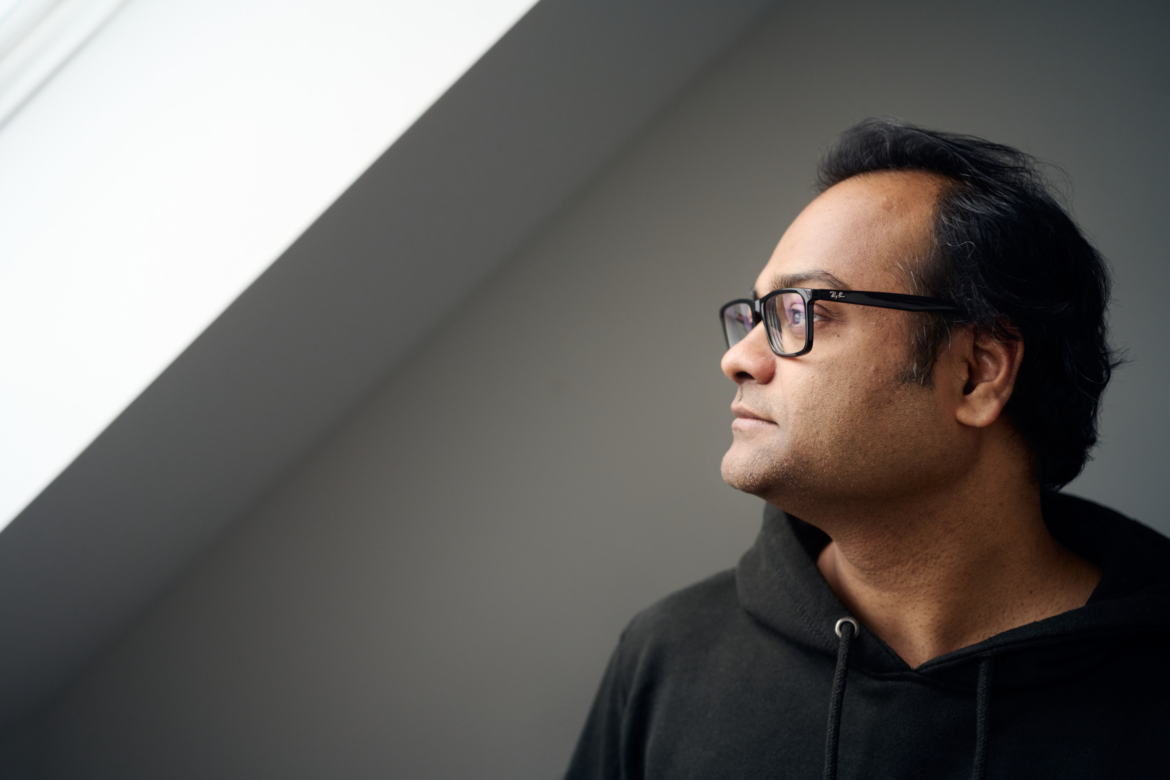 Author Santosh gazing out a window in his office