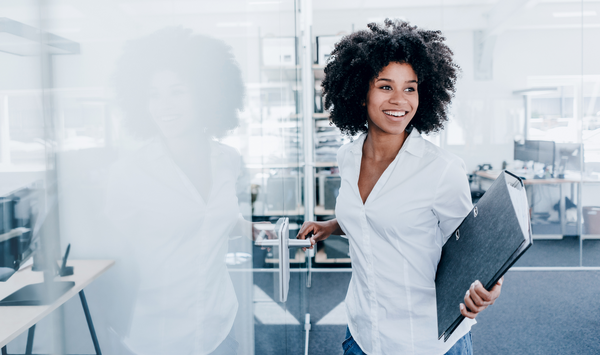 Woman in an office with folder in hand