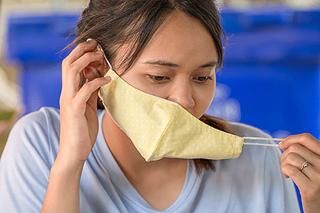 Woman putting on a face mask with elastic ear loops