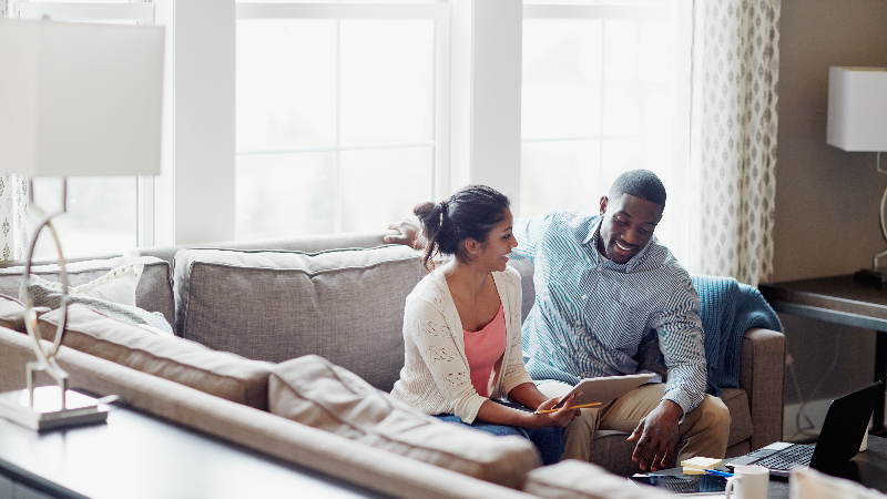 Shot of a young couple going through paperwork together on the sofa at home