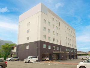 姬路Comfort Inn Himeji Yumesakibashi的一座白色的大建筑,汽车停在停车场