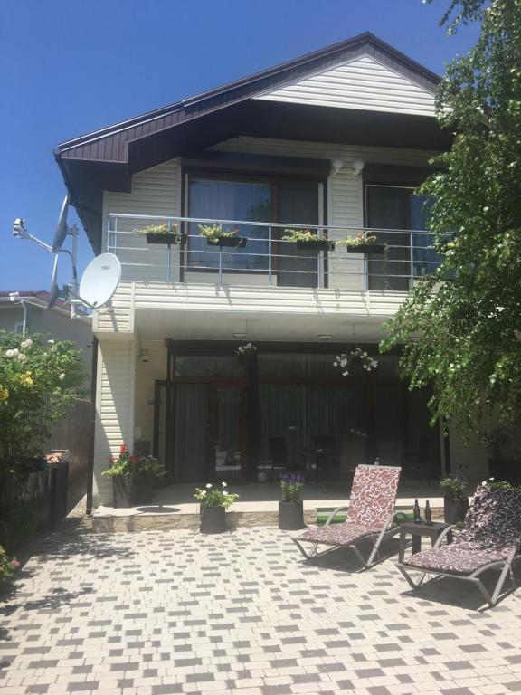 une maison avec 2 chaises sur une terrasse dans l'établissement Villa Life, à Zatoka