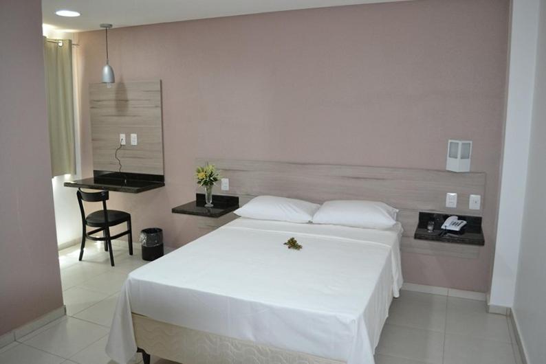 1 dormitorio con 1 cama blanca grande y escritorio en Hotel La Ville en Sousa