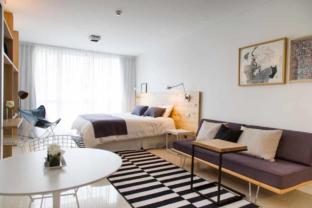 a bedroom with a bed and a couch and a table at Lemon Suites in Buenos Aires