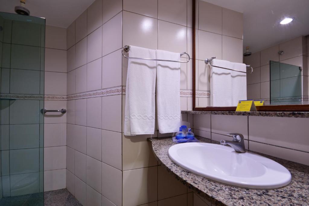 bagno con lavandino e specchio di Littoral Hotel a João Pessoa