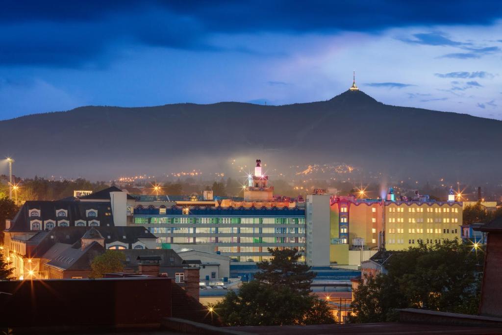 eine Stadt in der Nacht mit einem Berg im Hintergrund in der Unterkunft Wellness Hotel Babylon in Liberec