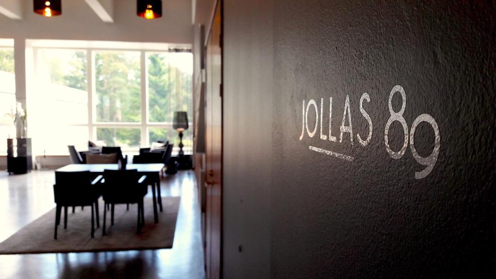 una sala da pranzo con tavoli e sedie e un cartello sul muro di Hotel Jollas89 a Helsinki