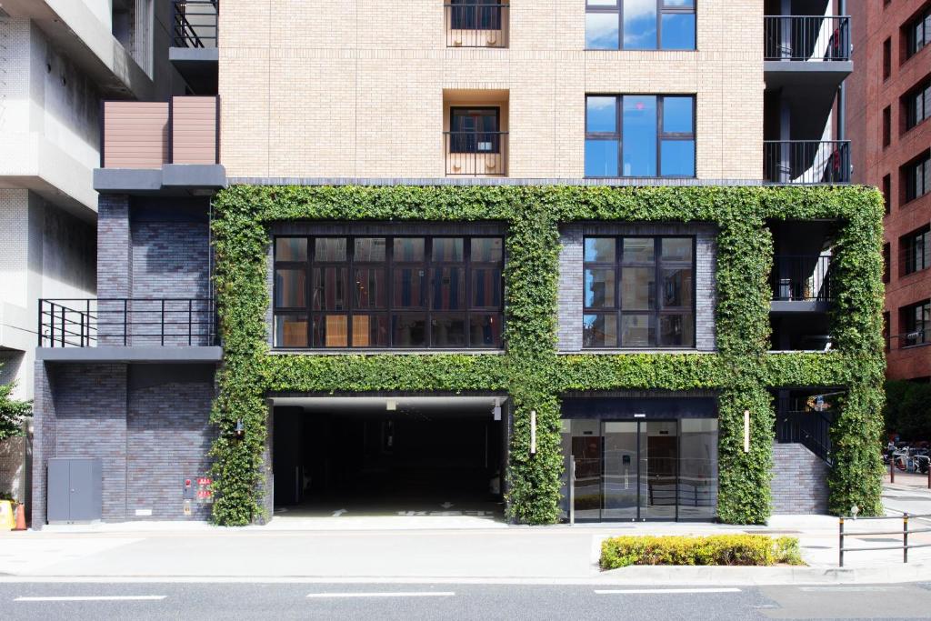 un bâtiment avec du lierre sur son côté dans l'établissement BRENZA HOTEL, à Kobe