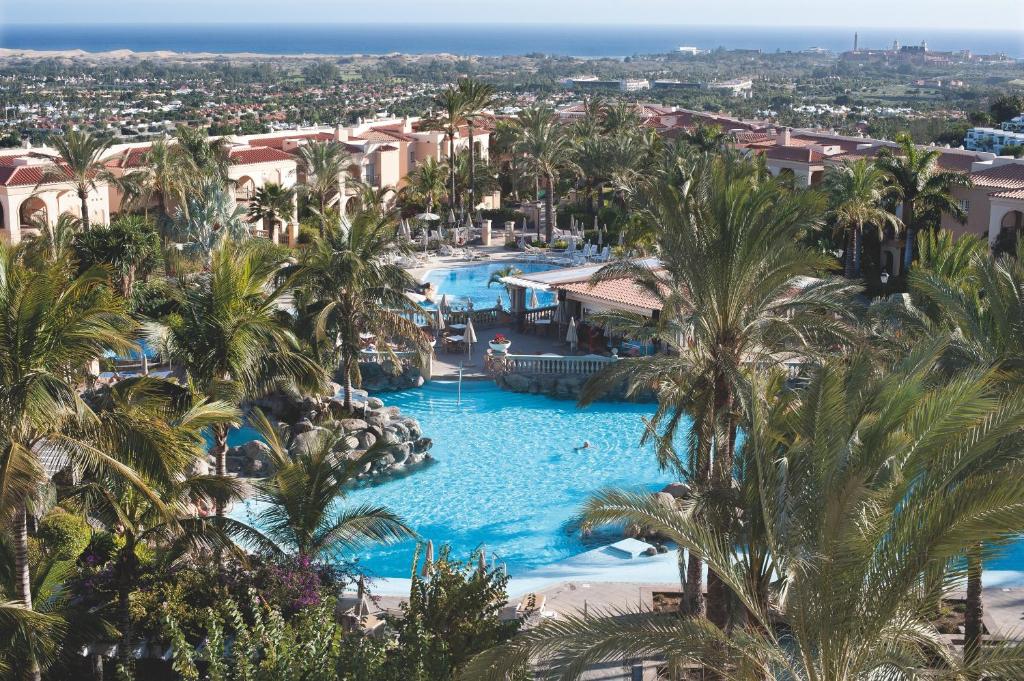 una vista aérea de una piscina del complejo con palmeras en Palm Oasis Maspalomas en Maspalomas