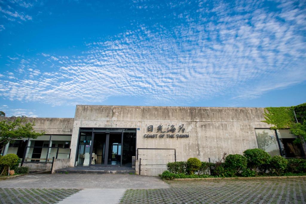 un edificio di cemento con un cielo azzurro con nuvole di Dayspring Inn a Nangan