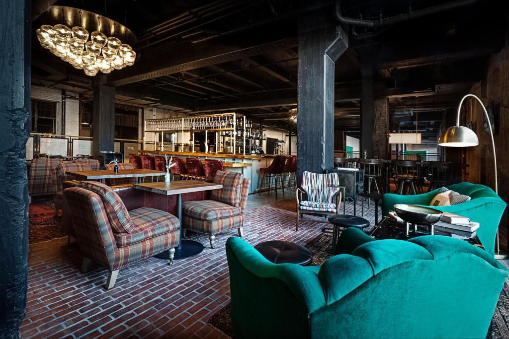 Cette grande chambre comprend des canapés, des tables et des chaises. dans l'établissement Crossroads Hotel, à Kansas City