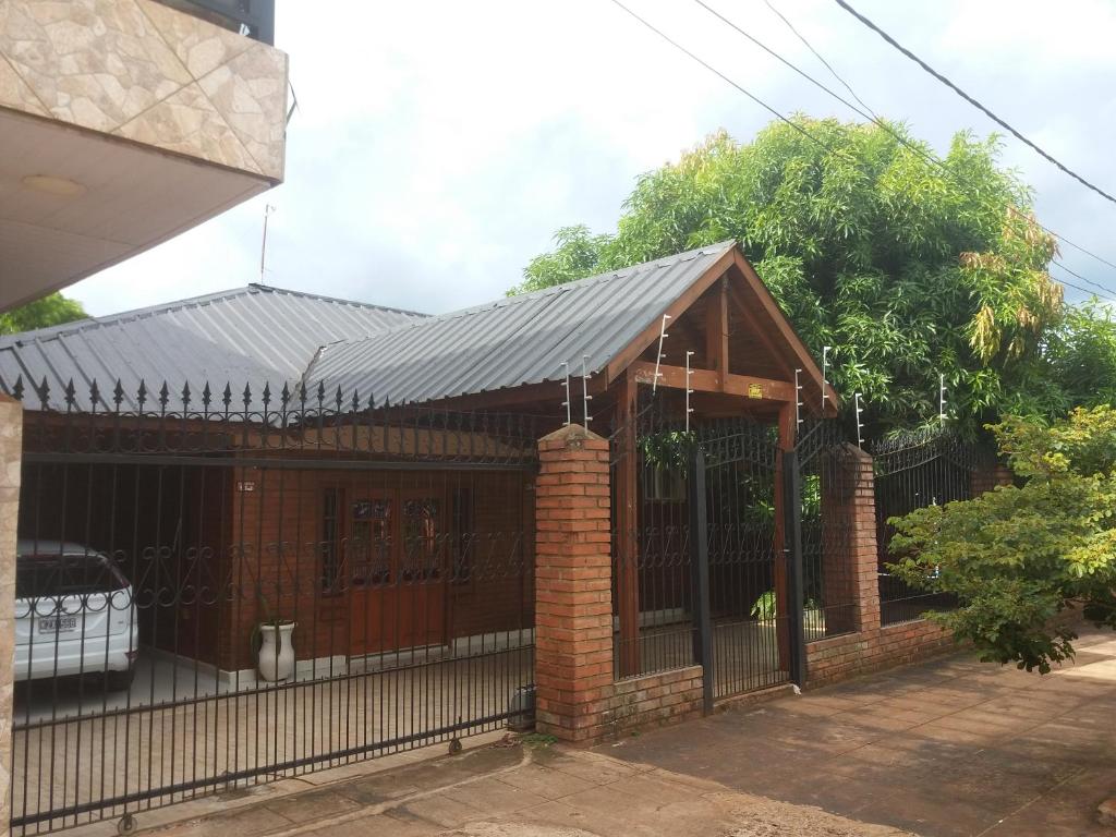 una casa con techo de metal y valla en Lo de Chawi en Puerto Iguazú