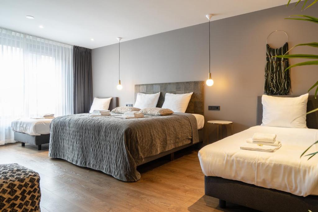 een hotelkamer met 2 bedden in een kamer bij Boutique Suites Lisse - Schiphol in Lisse