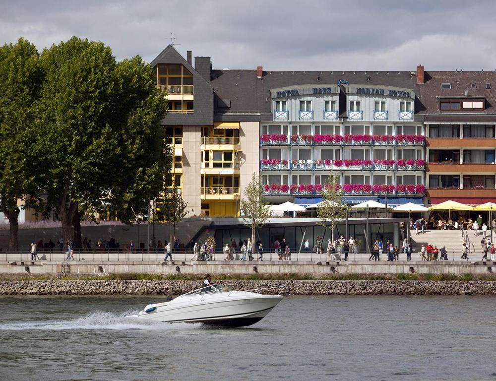 een boot in het water voor een gebouw bij Hotel Morjan in Koblenz