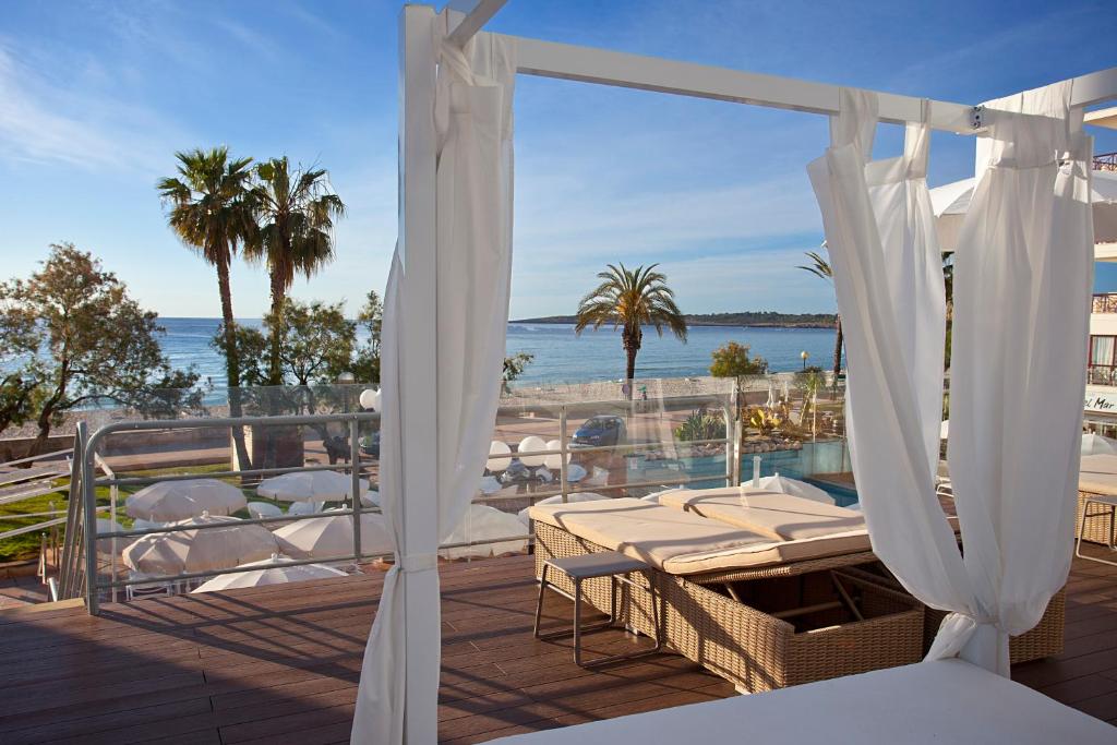 een balkon met een tafel en stoelen en de oceaan bij BLUESEA Anba Romaní in Cala Millor