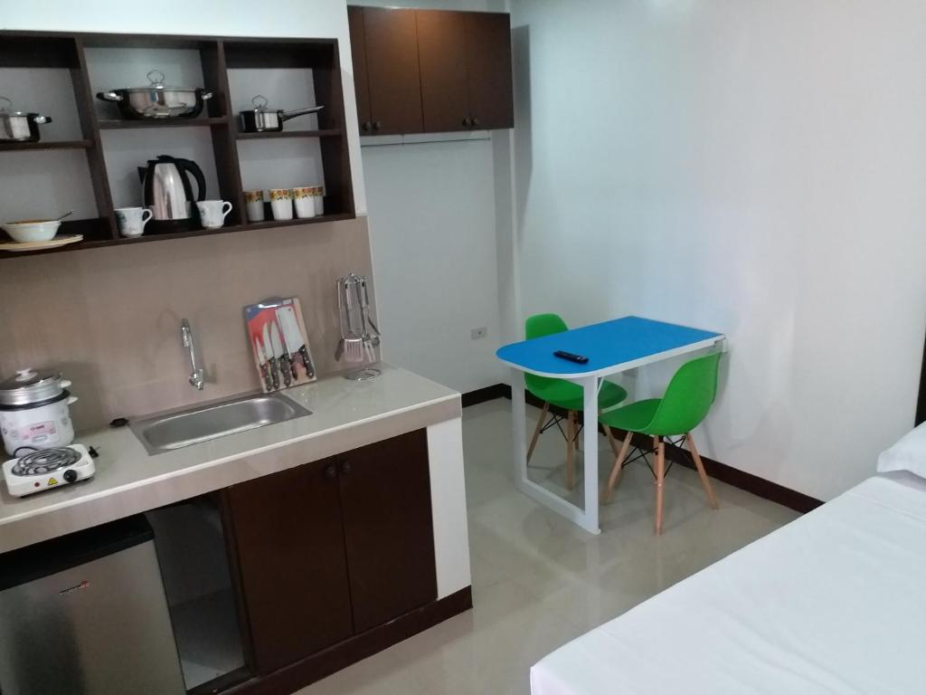 a kitchen with a sink and a blue table at Clark-Pad Inn, Angeles City in Angeles