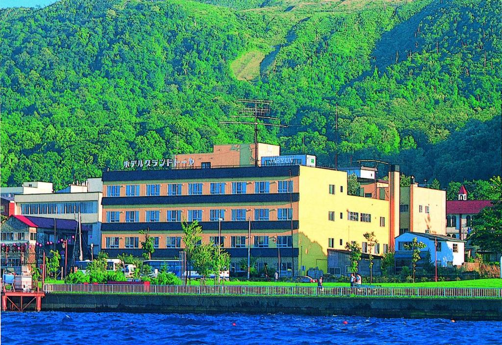 ein großes Gebäude neben einem Wasserkörper in der Unterkunft Hotel Grand Toya in Tōya-See