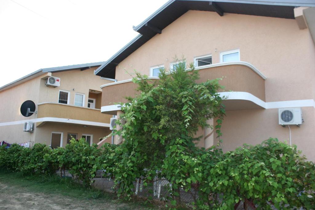 ein Gebäude mit einem Baum davor in der Unterkunft Apartments EMERALD in Ulcinj