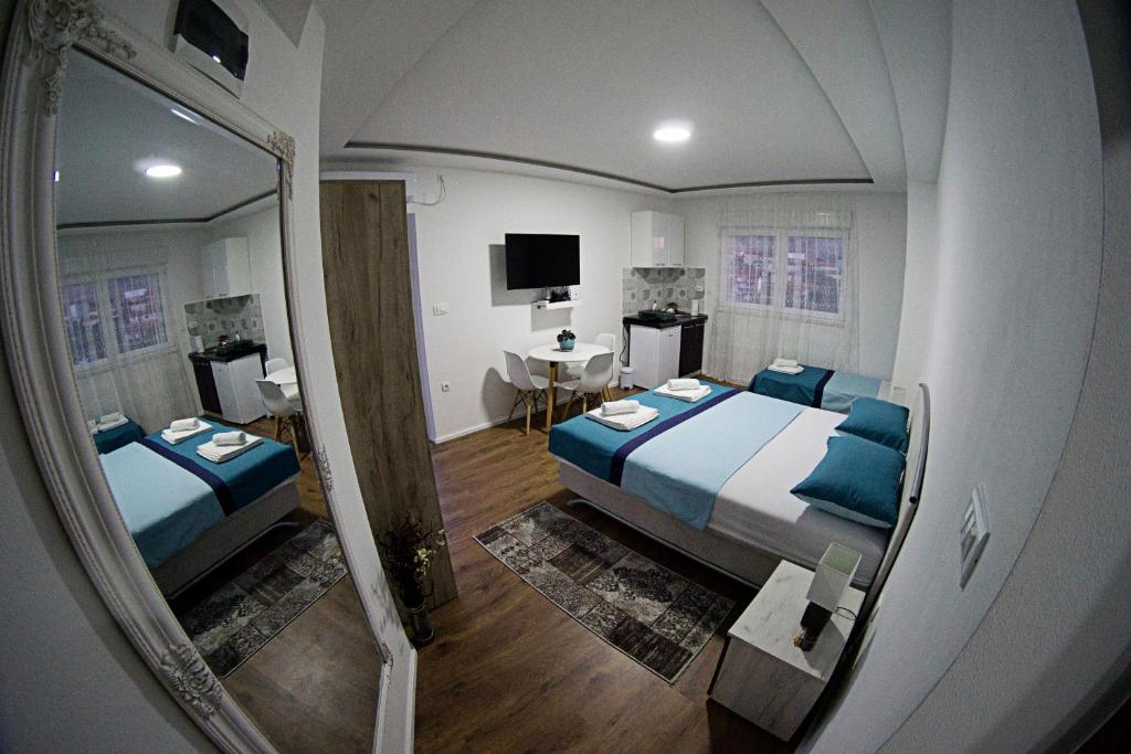 uma vista para um quarto com 2 camas e um espelho em Apartmani HM em Trebinje