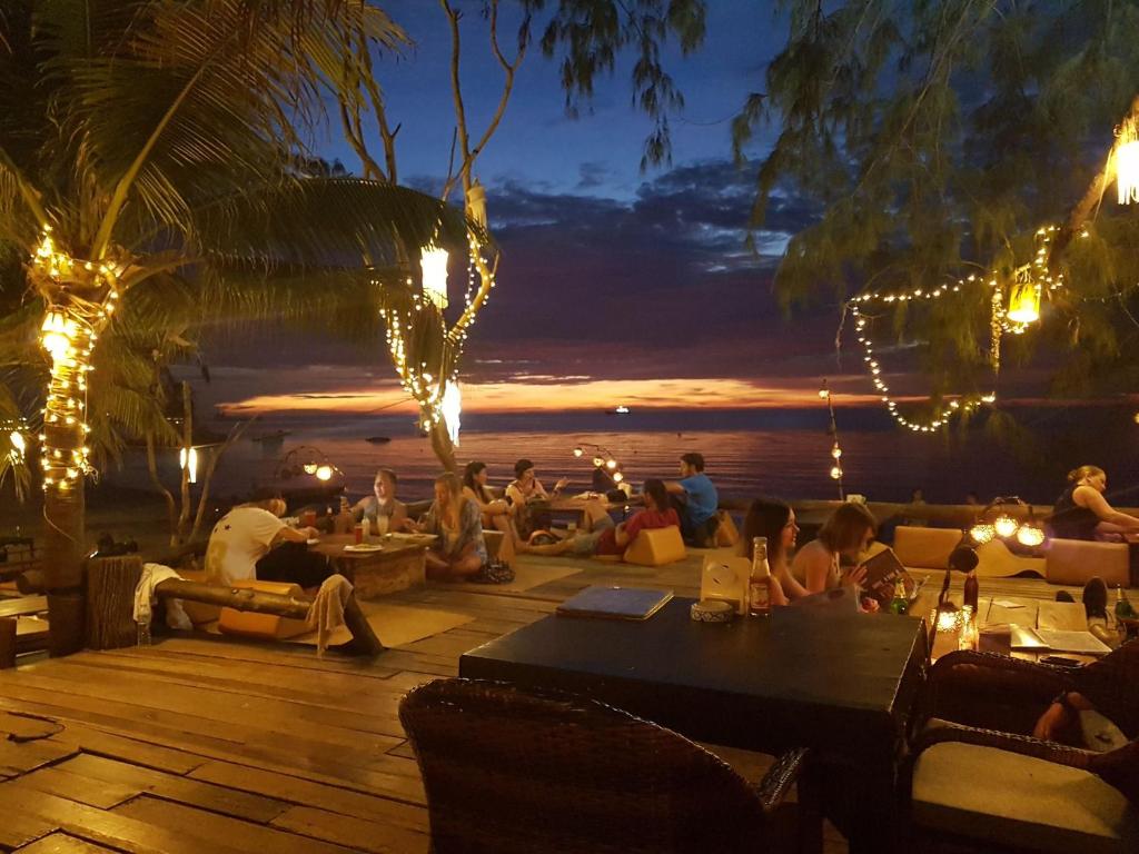 Eine Gruppe von Menschen, die auf einem Deck sitzen und den Sonnenuntergang beobachten. in der Unterkunft In Touch Resort in Ko Tao