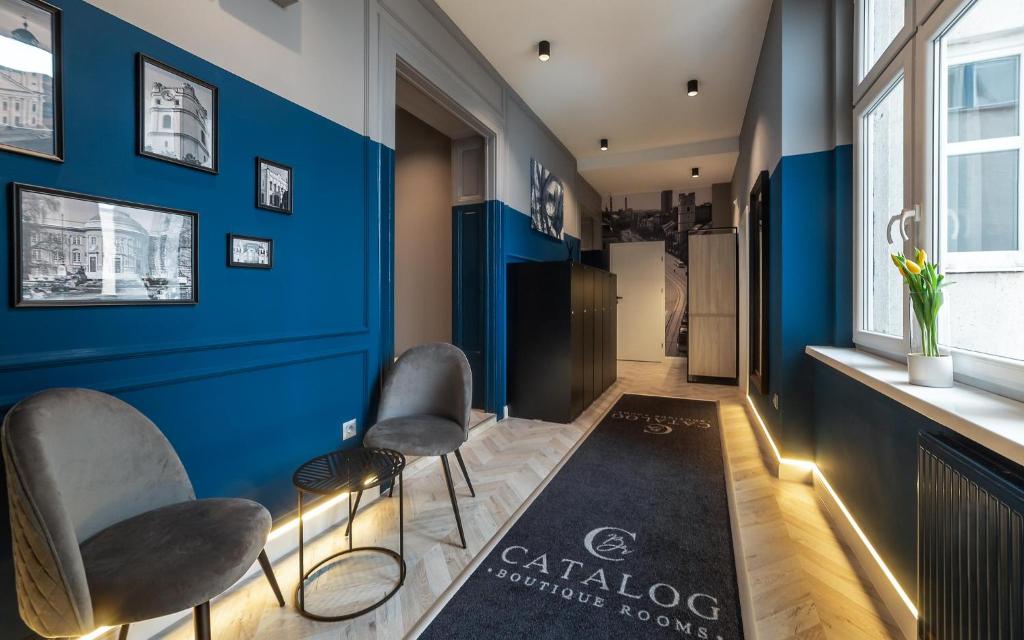 a room with blue walls and chairs and a rug at Catalog Boutique Rooms in Debrecen