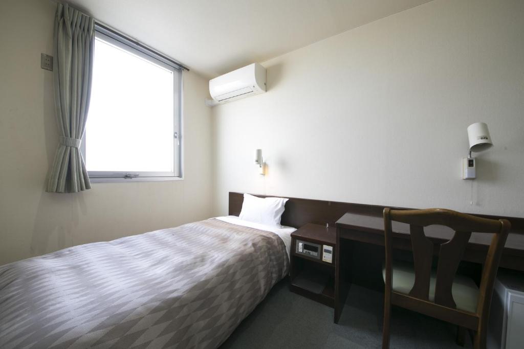豐橋的住宿－Okadaya Bayside / Vacation STAY 72733，一间卧室配有一张床、一张书桌和一个窗户。