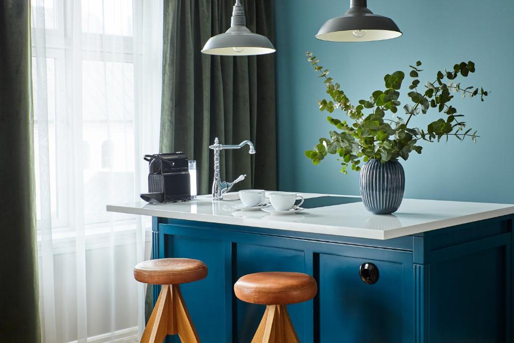 a blue kitchen with a counter with two stools at Kvosin Downtown Hotel in Reykjavík