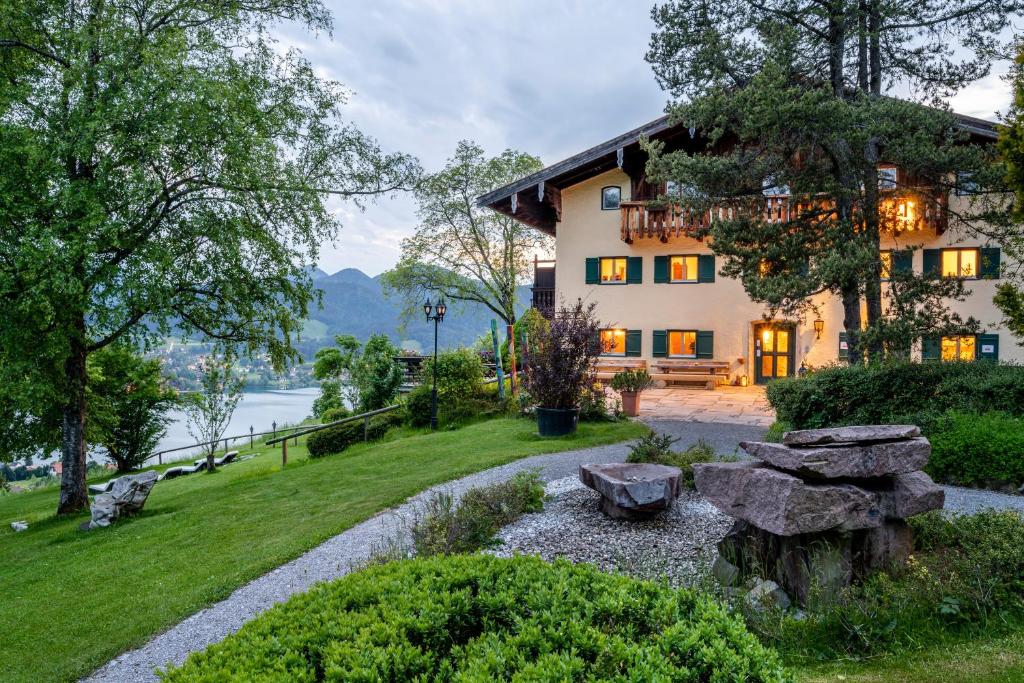 une maison avec un jardin en face d'un lac dans l'établissement Der Westerhof Hotel, à Tegernsee