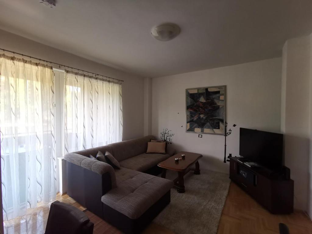 a living room with a couch and a tv at Apartman Banja - Tuzla in Tuzla