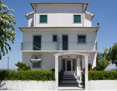 Cette grande maison blanche dispose d'un balcon. dans l'établissement Hotel Novo Dia, à Mêda