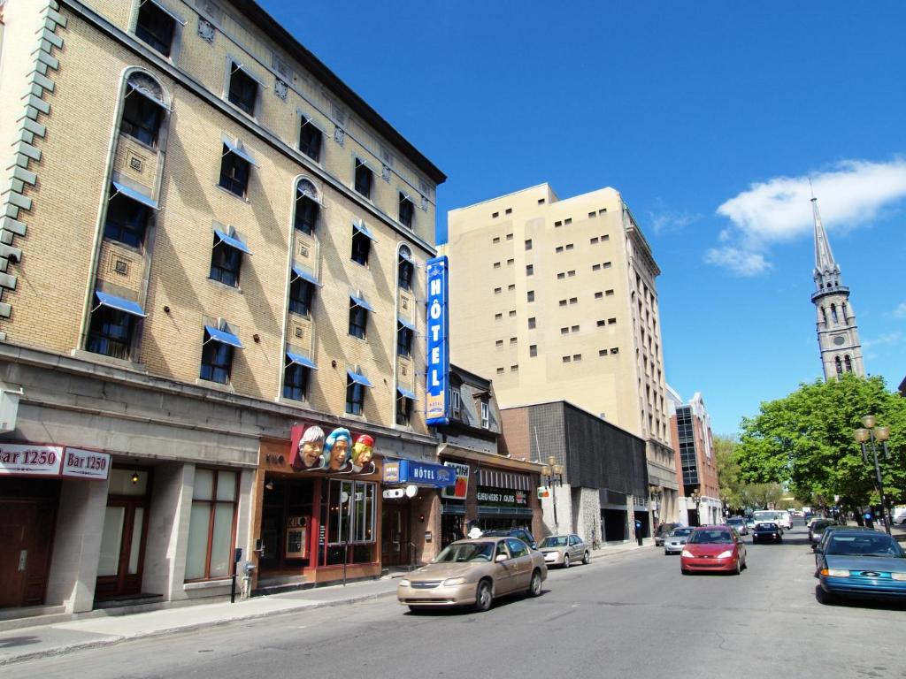 uma rua da cidade com carros estacionados na rua em Hotel St-Denis em Montreal