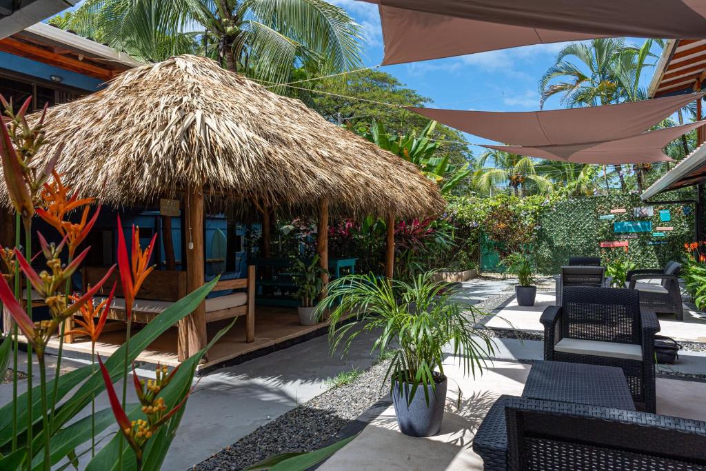 um restaurante com guarda-sol de palha, cadeiras e plantas em Point Break Santa Teresa em Santa Teresa