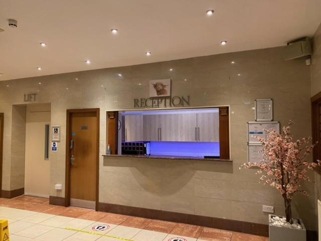 einen Empfangsbereich eines Krankenhauses mit einem TV an der Wand in der Unterkunft West Park Hotel in Clydebank