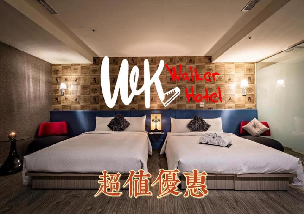 Walker Hotel - Zhengyi في تايبيه: سريرين في غرفة مع لافتة مكتوب عليها فندق سوق المملكة المتحدة