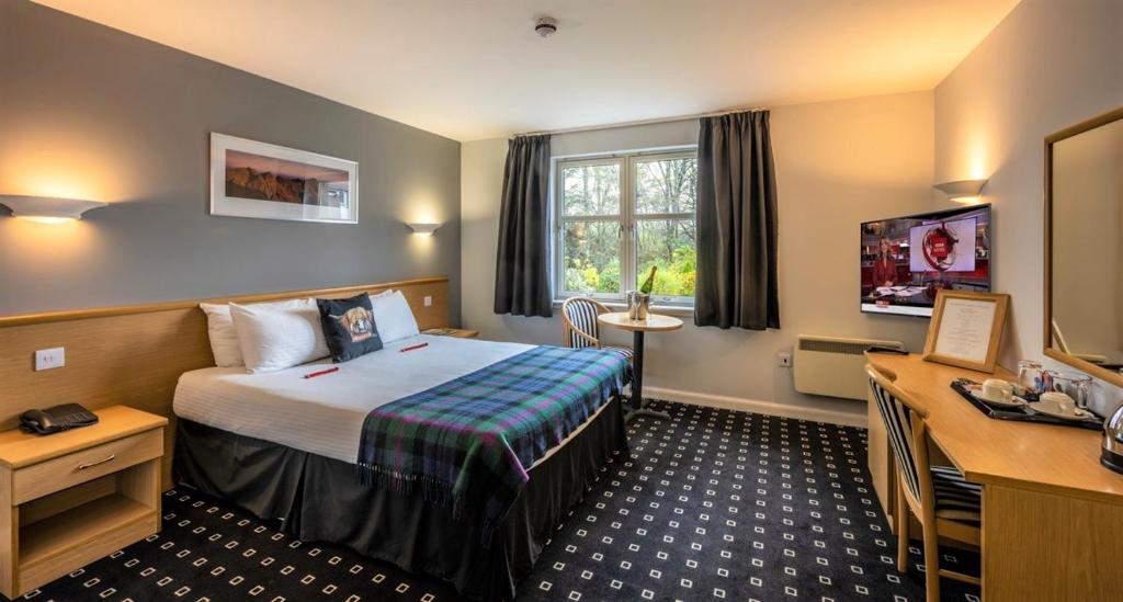 Habitación de hotel con cama y TV en Pinehurst Lodge Hotel - Aberdeen, en Dyce