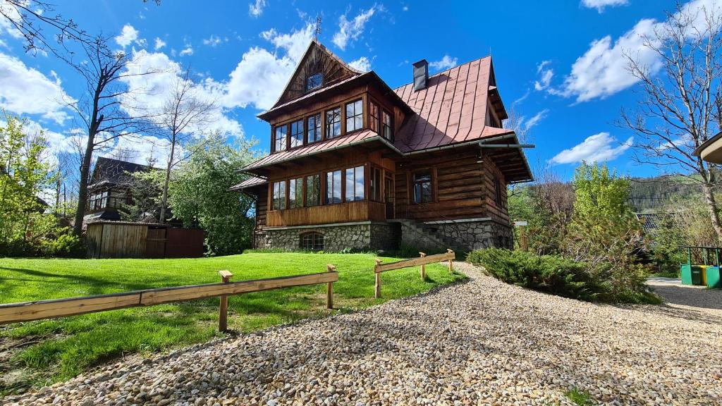 una gran casa de madera con una valla delante de ella en Willa Rawa, en Zakopane