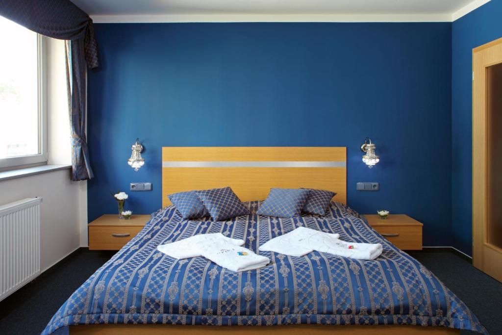 um quarto azul com uma cama com duas toalhas em Hotel U Karla em Praga