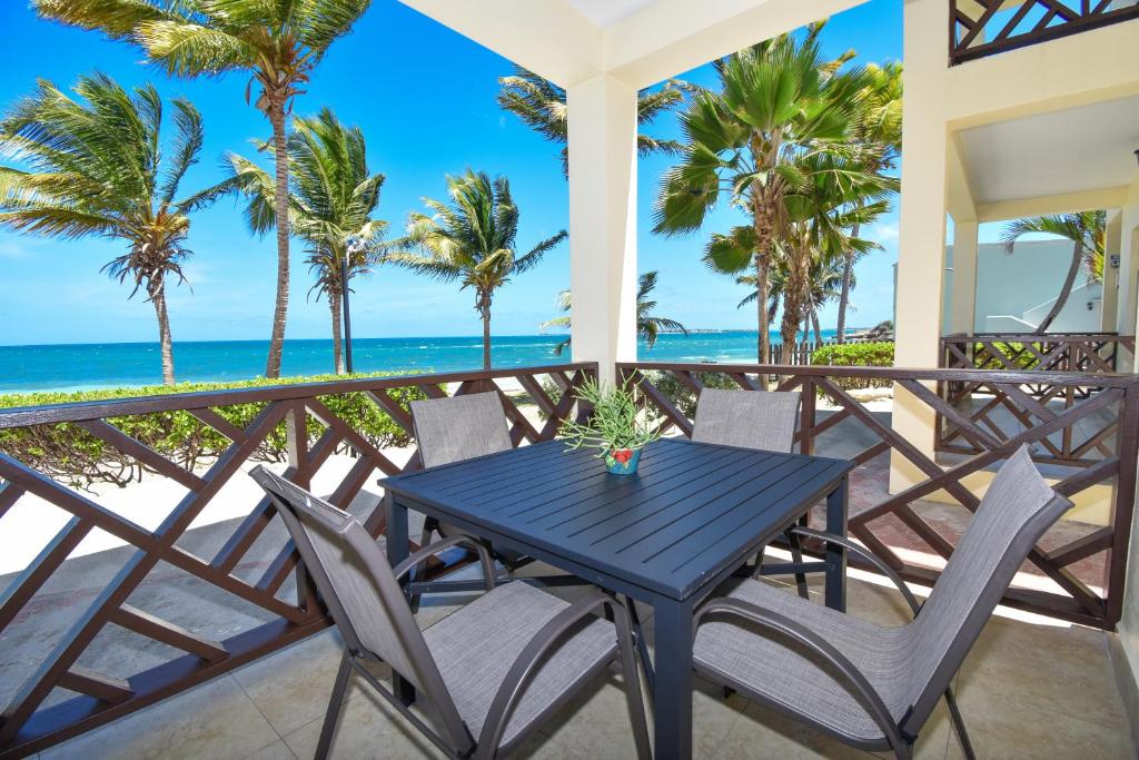 een blauwe tafel en stoelen op een balkon met uitzicht op het strand bij Lord Nelson Hotel & Residences in Barnes Hill