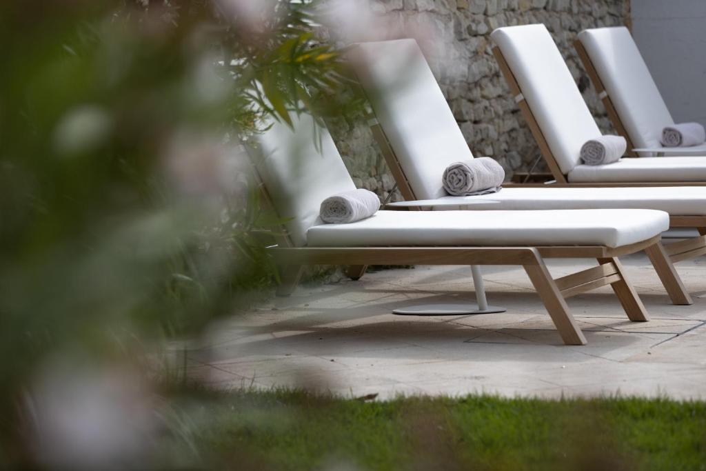 a row of white lounge chairs sitting on a patio at Villa Clarisse & Spa by Olivier Claire in Saint-Martin-de-Ré