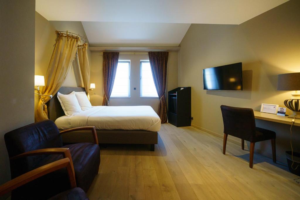 Habitación de hotel con cama, escritorio y silla en Hotel Saint-Amour en Durbuy