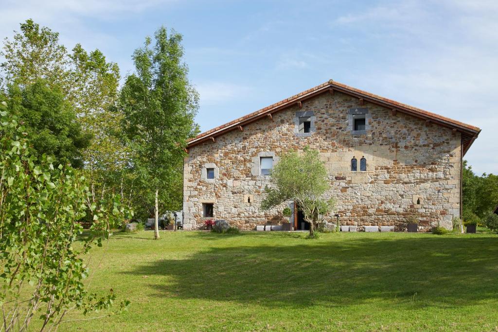 een oud stenen gebouw in een veld met bomen bij Heredad de Unanue in San Sebastian