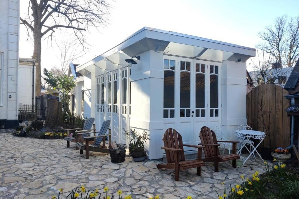 een kleine schuur met stoelen en een tafel in een tuin bij Oranjerie, 7 km onder Groningen in Paterswolde