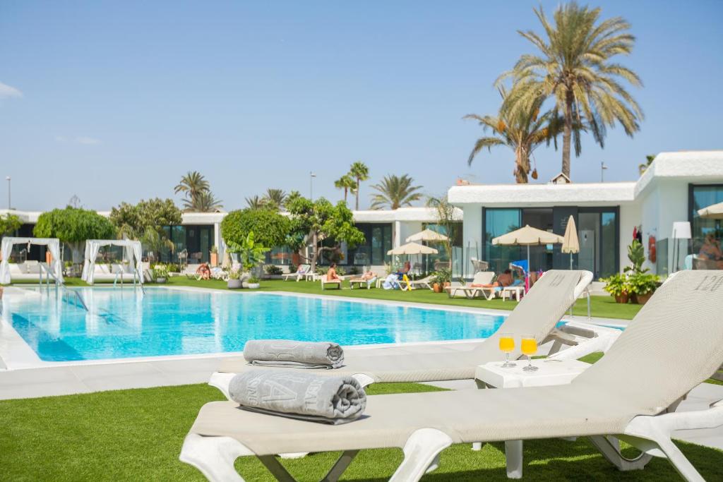 Villa con piscina y tumbonas en Bungalows Doña Rosa en Playa del Inglés