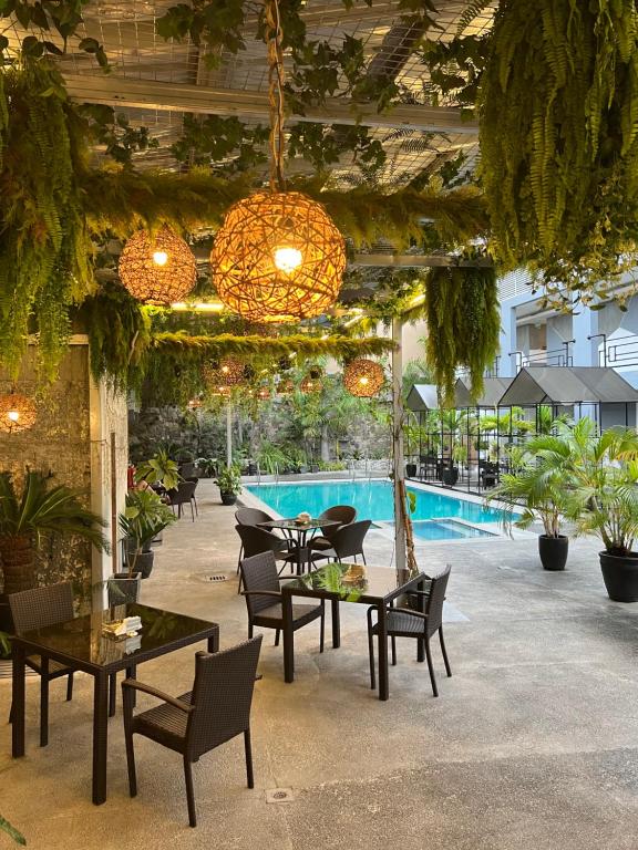 a patio with tables and chairs and a pool at Hotel Halo in Angeles