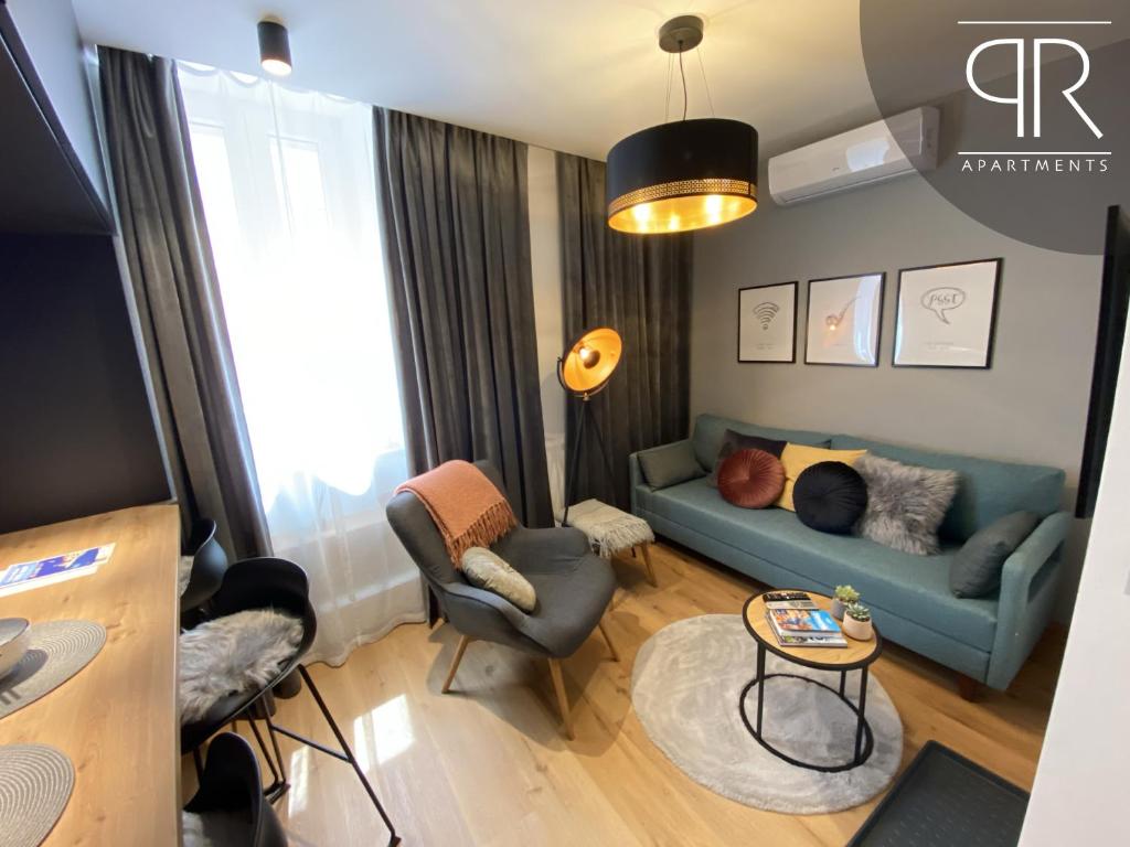 un soggiorno con divano blu e tavolo di Piran Rooftop Apartments a Piran